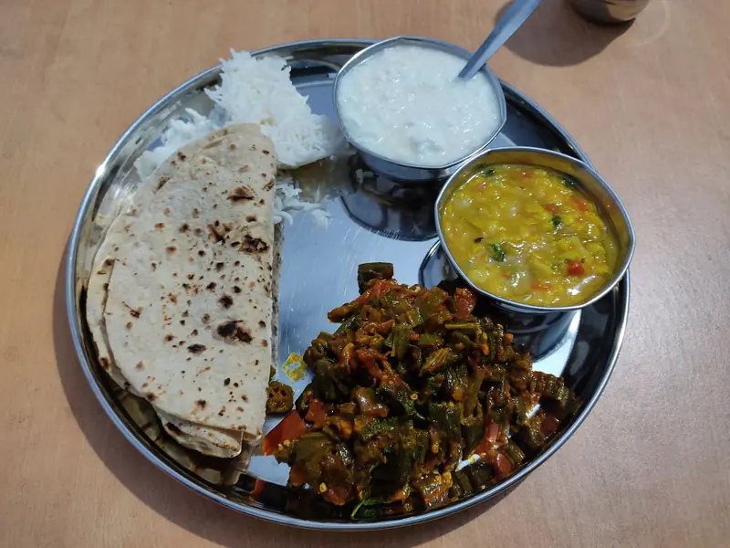 A balanced vegetarian Indian thali with roti, dal, bhindi sabzi, rice and curd for a PCOS diet